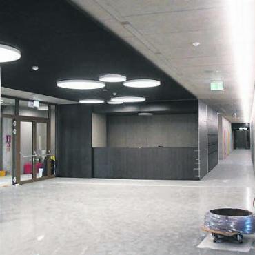 Einzigartig und modern - Der Entreebereich mit Foyer ist grosszügig gestaltet. Der Gang (rechts) führt zu den bunten Garderoben.