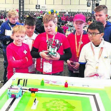 Der Roboter als Freund - Das Team Robo Matik Cobra (im roten Dress) mit dem Dottiker Alexander Gaier bei der Demonstration ihres Roboters. Bild: Monika Koch, WRO Schweiz