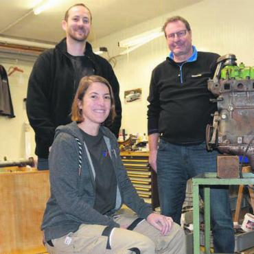 Gemeinsam für das Schmuckstück - Die Sitzbank, auf der Jolanda Hofmann sitzt, wurde bereits abgeschliffen. Auch der Motor wird überarbeitet. Michael Baur, Präsident des Feuerwehrvereins Waltenschwil (links), und Pirmin Imboden sind mit dem Verlauf der Restauration bisher zufrieden. Bilder: Sabrina Salm / zg