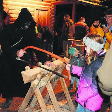 Beim Samichlaus daheim - Beim Holzsägen mit dem Schmutzli sind Muskeln gefragt.