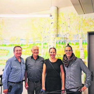 In die Landschaft eintauchen - Sie haben Freude am grossen Wandbild in der Cafeteria, von links: Markus Weishaupt, Leiter Gastronomie, Laudator Arnold Rossi, die Künstlerin Gisela Elwina Kämpf und der Musiker Matt Stöckli. Bild: zg