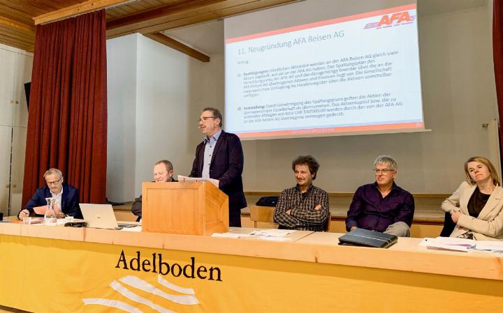 AFA-Verwaltungsratspräsident Hanspeter Frautschi (stehend) erklärt den Anwesenden im Adelbodner Kirchgemeindehaus, was das Firmen-Splitting für ihre Aktien bedeutet. BILD: BIANCA HÜSING