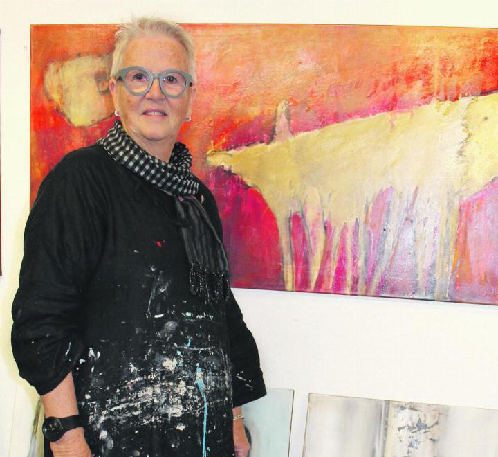 Edith Konrad vor ihren Werken in einem Kleid, genäht von einer Sri-Lankerin.